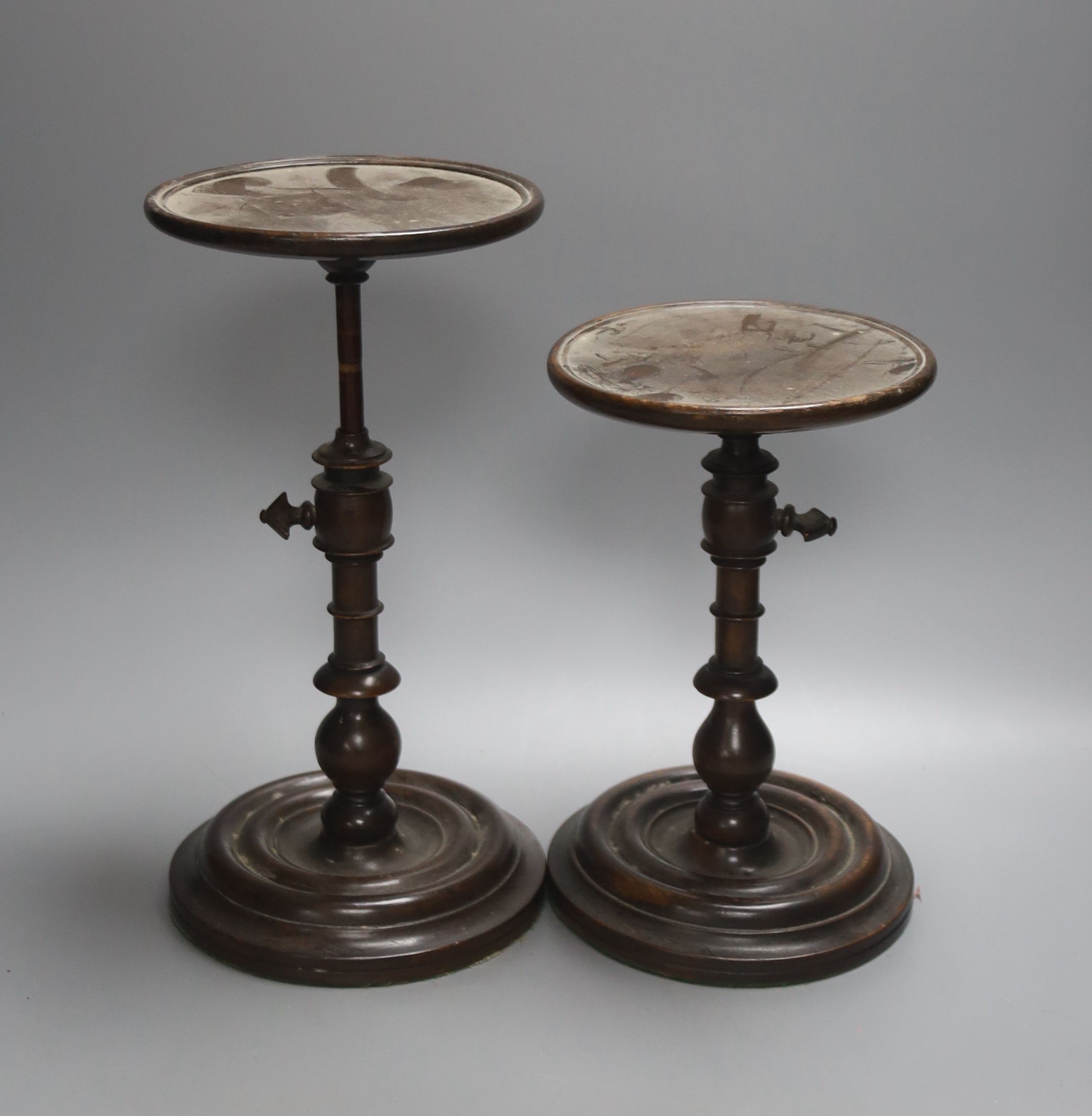 A pair of Georgian style stained beech adjustable candle stands, height 24cm